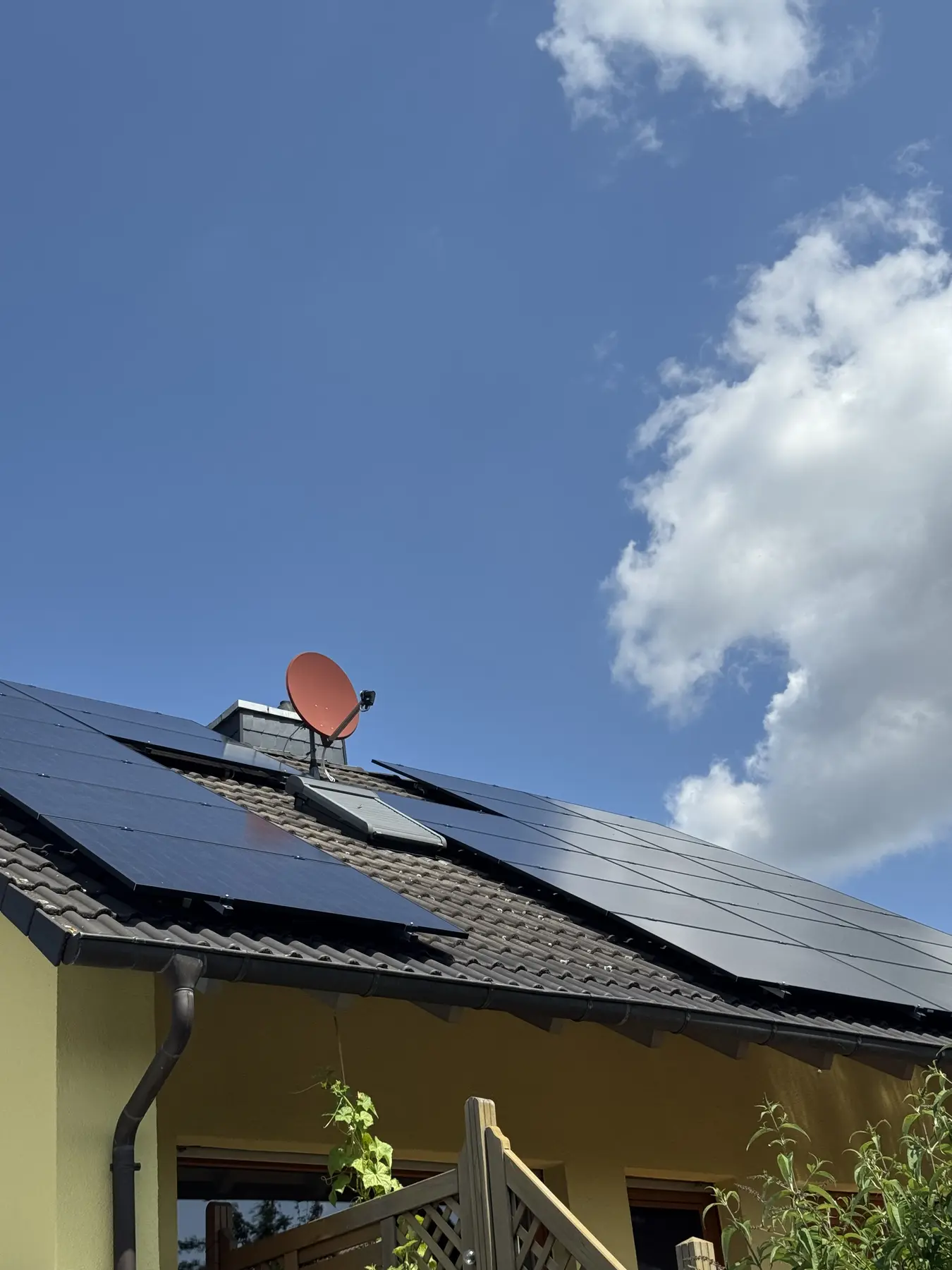 Photovoltaikmodule auf einem Schrägdach unter blauem Himmel
