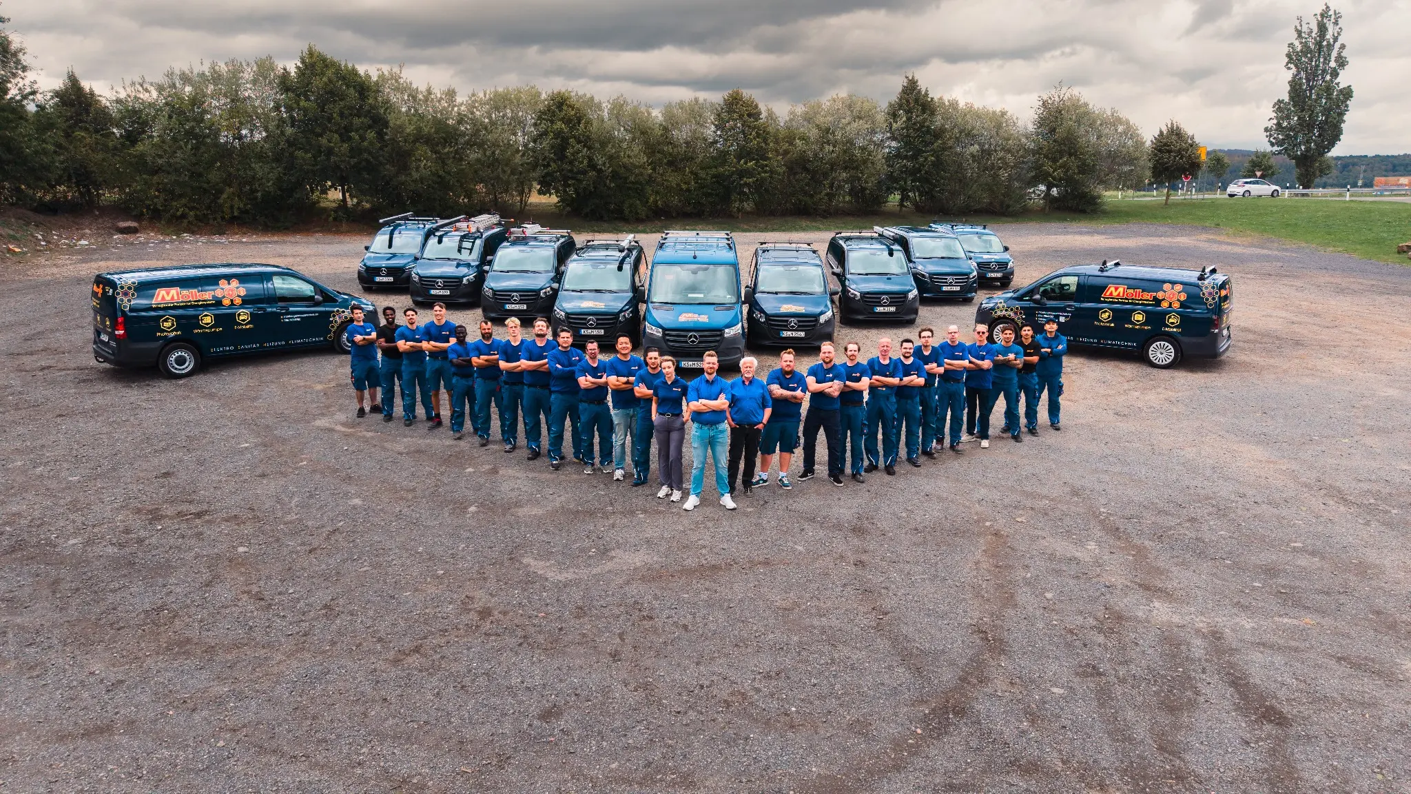 Das gesamte Möller-Team vor dem Firmenfuhrpark